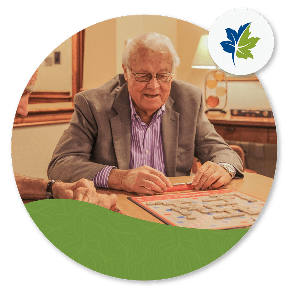 older man sitting at table playing scrabble